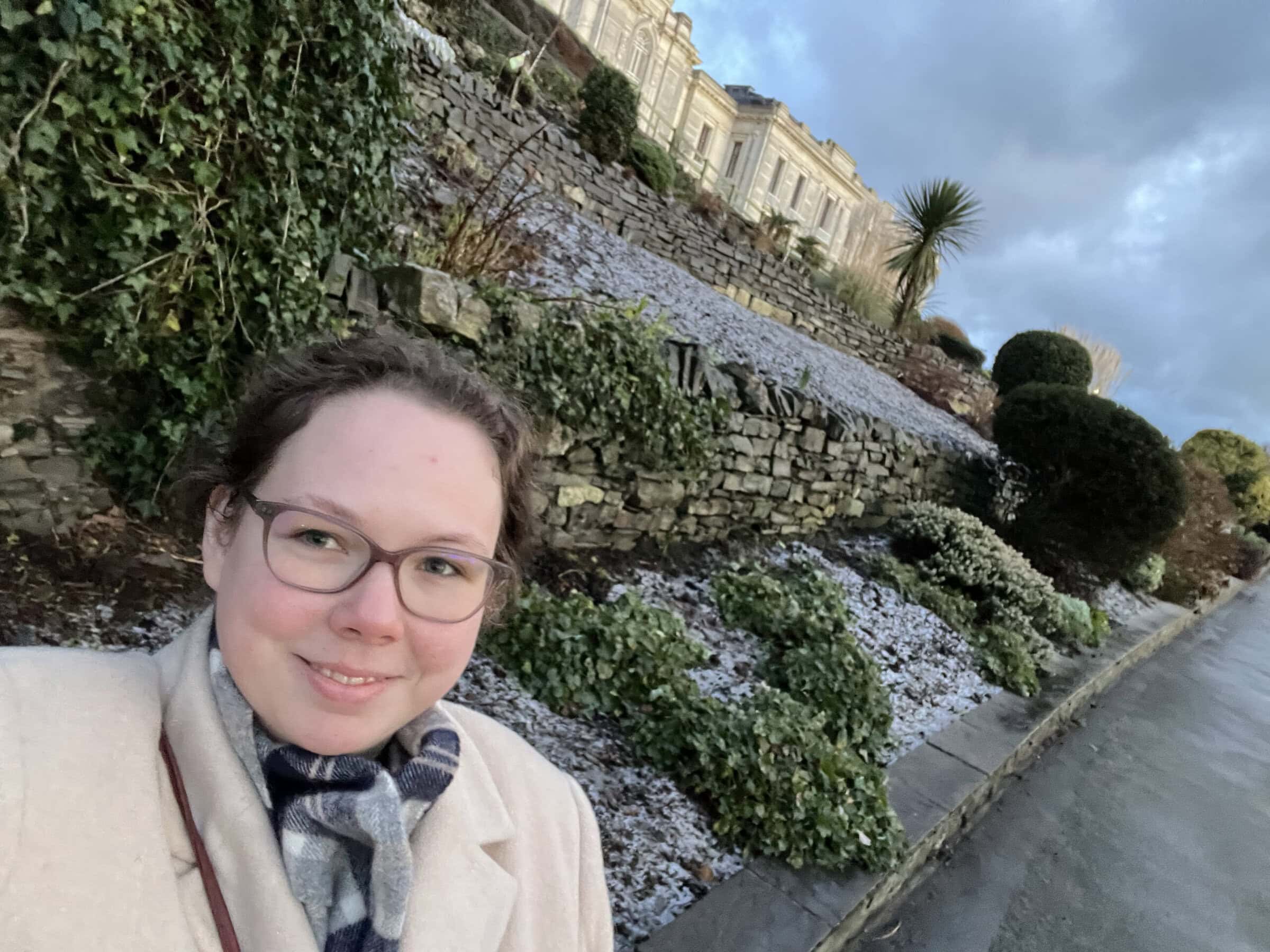 Elizabeth Bailey poses for selfie in front of the National Library of Wales while conducting research there