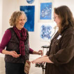 Artist Ann Holsberry works with students to install her work