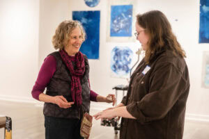 Artist Ann Holsberry works with students to install her work 