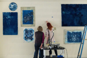 Artist Ann Holsberry works with students to install her work 