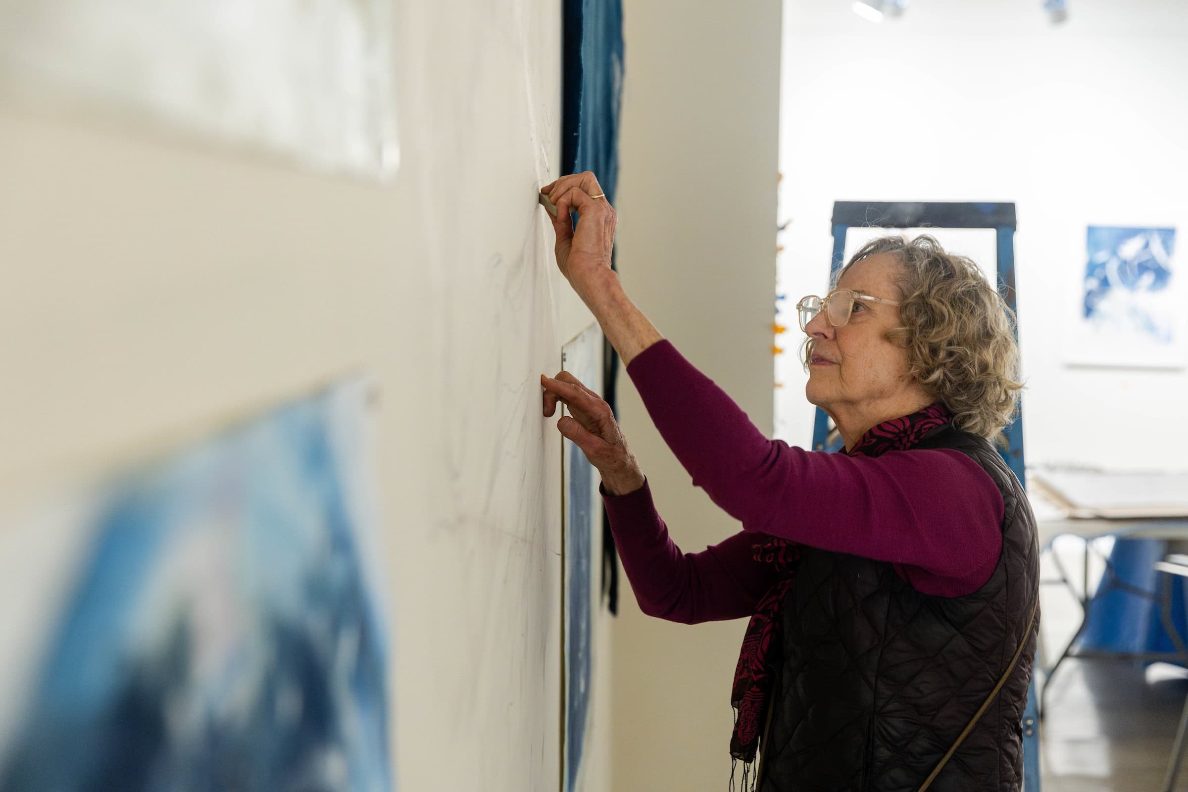 Ann Holsberry hangs some of her art in the Maier Museum 