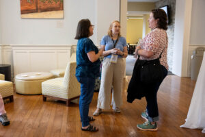 A group of women standing together talking.