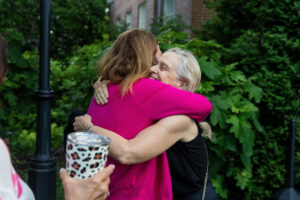 Two alums embrace while reuniting on campus