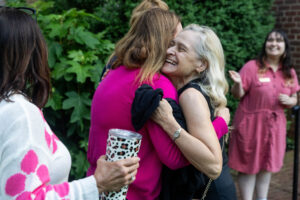 Two alums embrace while reuniting on campus