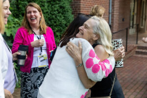 Two alums embrace while reuniting on campus