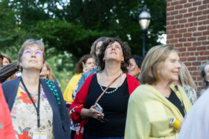 Alums listen in the crowd while professor Gerry Sherayko leads a walking tour on campus during Reunion