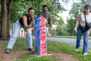 Alums spray paint the Even Post during Reunion