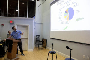 A man speaking to a crowd in a lecture hall.