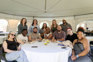 A table of alums sit together and pose for a photo during Reunion