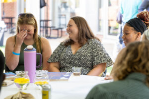 A table of alums sit and laugh together during Reunion