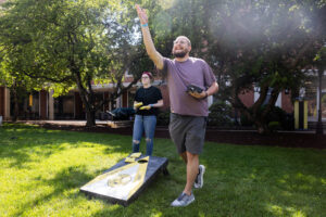 Two alums play a game of cornhole during Reunion