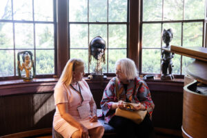 Two alums speak while sitting down inside Randolph House