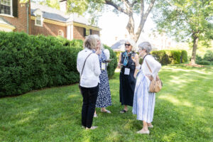 A group of alums talk outside of Randolph House
