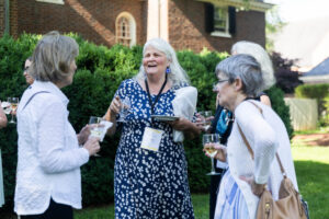 A group of alums talk outside of Randolph House