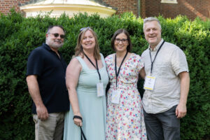 A group of alums pose for a photo together outside of Randolph House