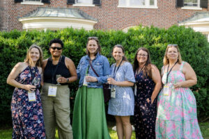 A group of alums pose for a photo together outside of Randolph House