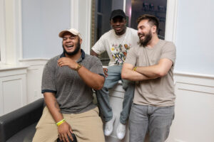 A group of three male alums laugh together during Reunion
