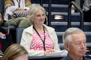 A woman sits in a lecture hall.