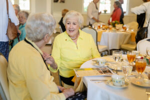 Two women talk to each other during an afternoon tea event 