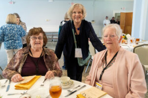 Three women sitting at a table with plates of food.
