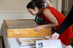 A woman looking at a book in a box.