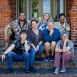 A group photo, with everyone sitting on the steps outside of Main Hall