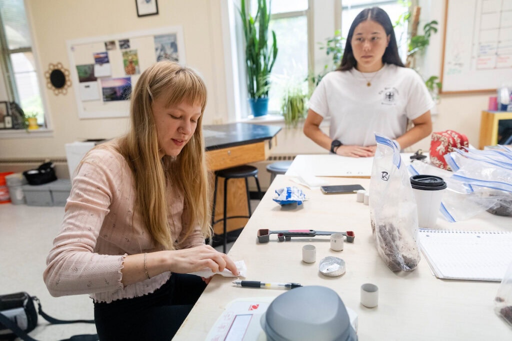 Two women working on a project in a classroom.