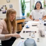 Two women working on a project in a classroom. Two women working on a project in a classroom.