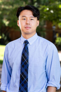 A man stands outside posing for a photo 