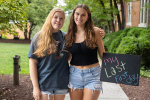 Two students pose with a chalkboard that says "The Life of a WildCat"