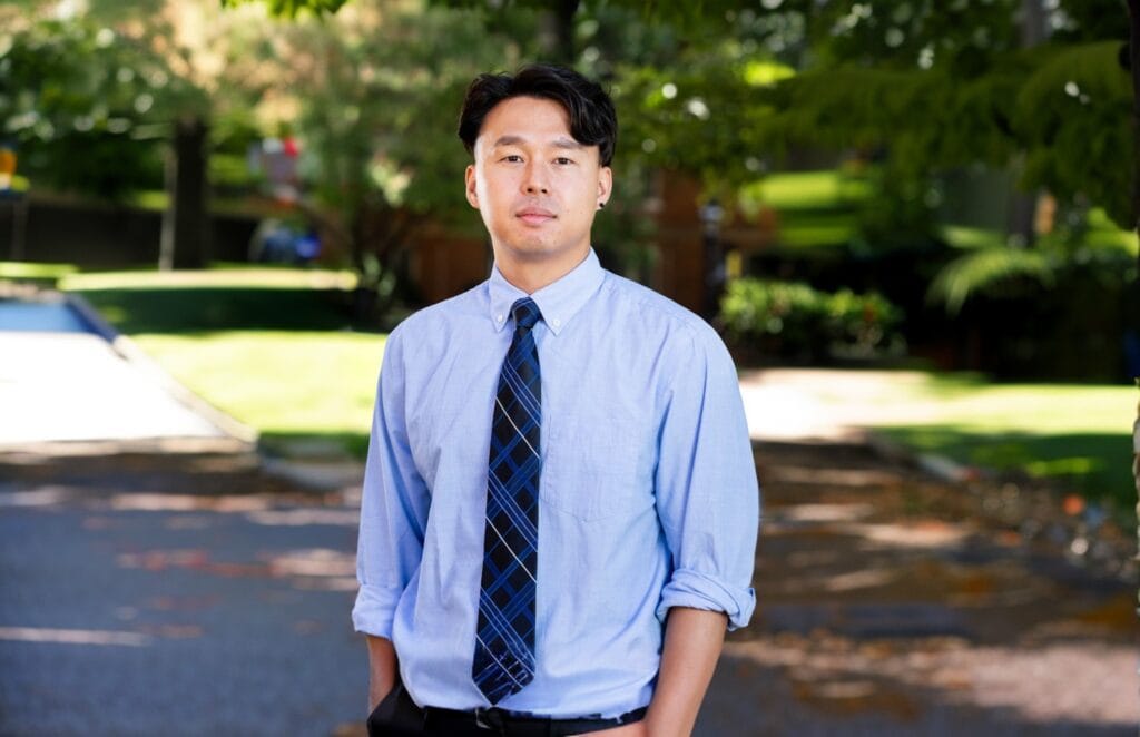 A man stands outside posing for a photo