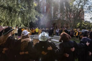 Students stand arm-in-arm around the Sundial 