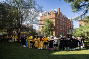 Students stand arm-in-arm around the Sundial 
