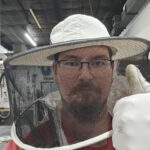A mean wearing a bee suit gives the thumbs up in a selfie