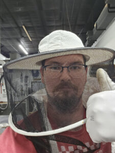 A mean wearing a bee suit gives the thumbs up in a selfie 