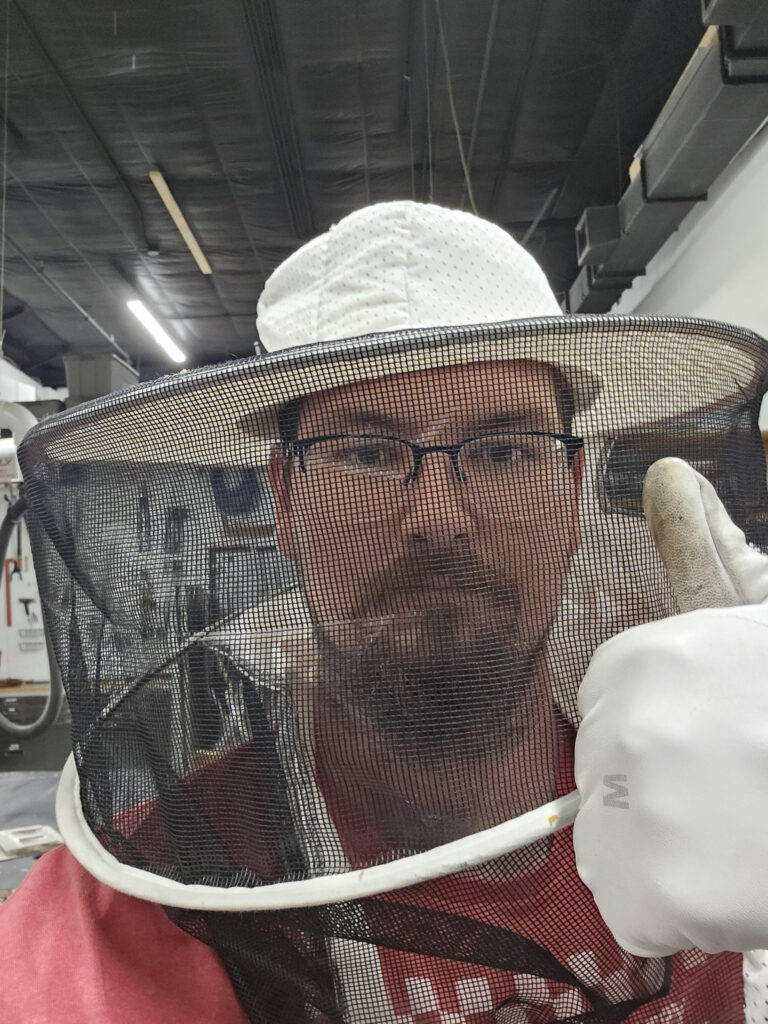 A mean wearing a bee suit gives the thumbs up in a selfie