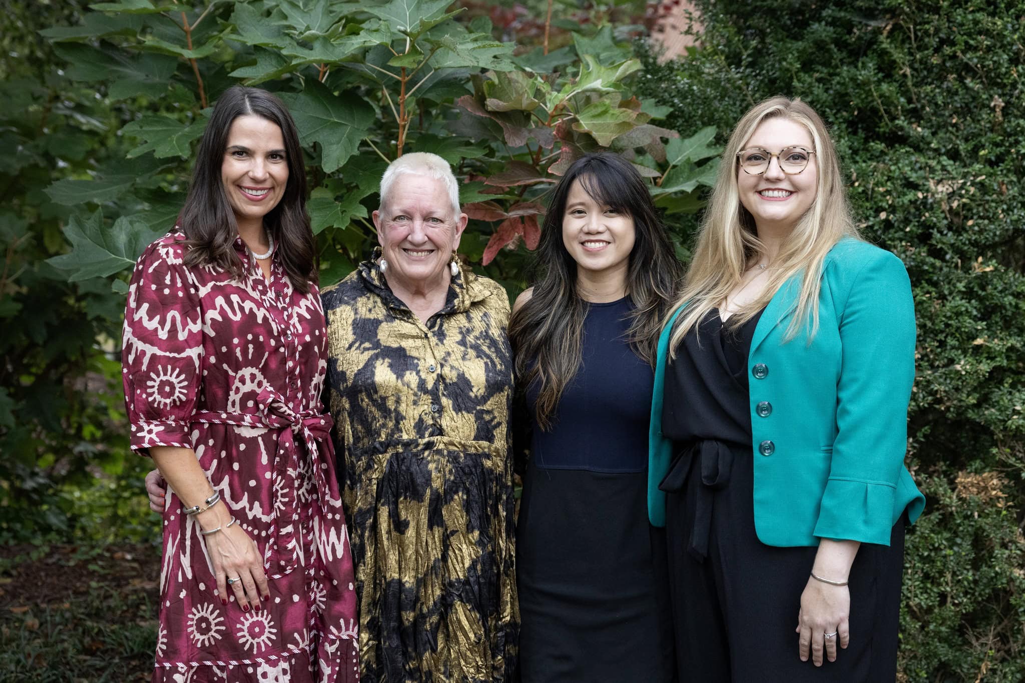 Four women post together for a photo 
