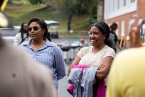 A group of people talk and laugh during a tailgate event 