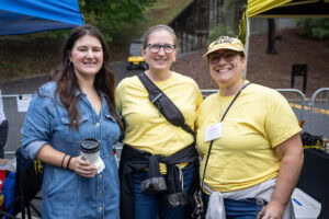Three people pose for a photo together 