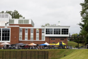 A distant shot of a tailgate event, with various canopies set up 