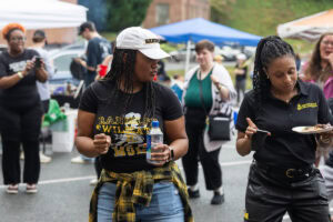 A group of people dances together outside during a tailgate event