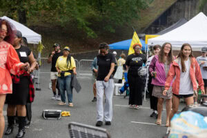 A group of people dances together outside during a tailgate event