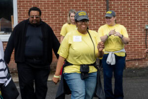 A group of people dances together outside during a tailgate event