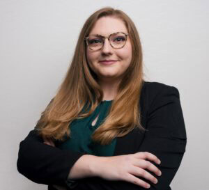 A woman poses for a photo with her arms crossed