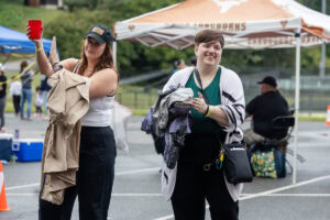 Two people stand together smiling during an outdoor event