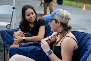 Two people sit and chat during a tailgate event 