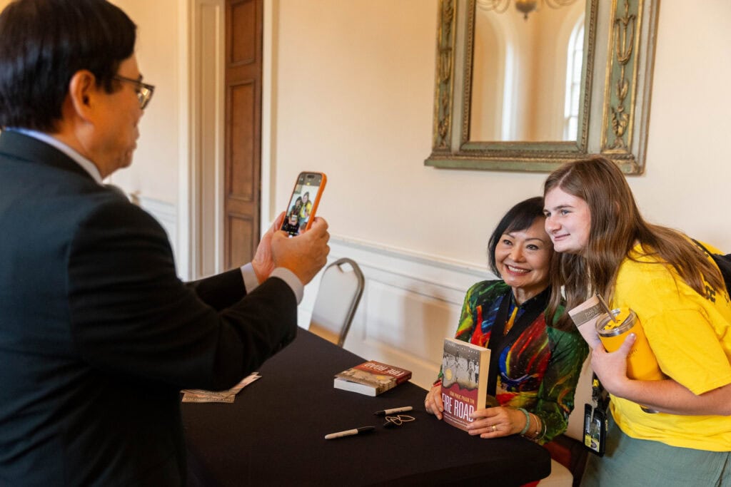 Kim Phuc Phan Thi poses for a photo with a Randolph student and her book, "Fire Road." 