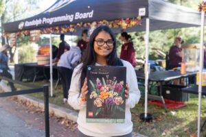 A student poses with a prize, a Lego project