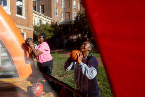 Two students shoot basketballs during an event