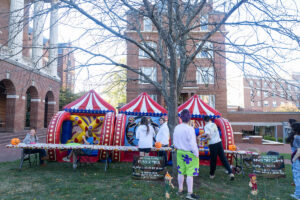 A student walks by several inflatable games during a fall festival